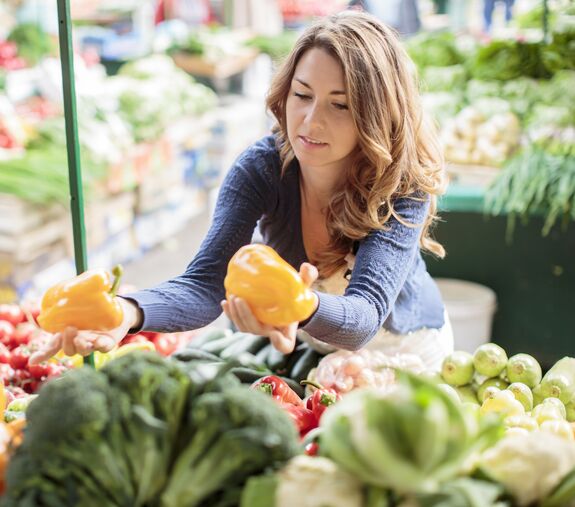 Eine Frau kauft frisches Gemüse auf dem Markt